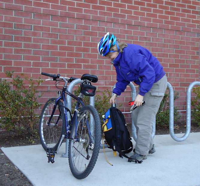 Cyclist Bending Down To Unlock Bike