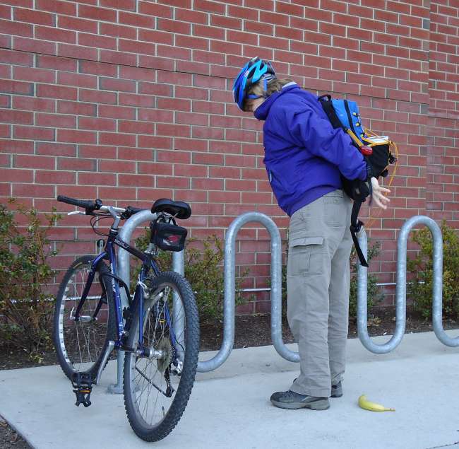 Cyclist Putting On Backpack