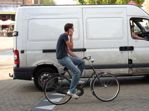 Man Riding Bike Using Cell Phone