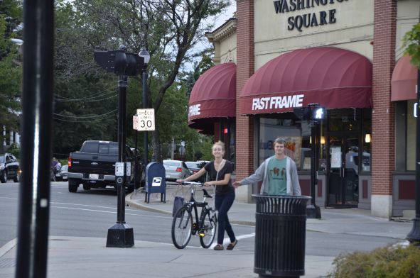 Woman And Man Crossing The Street With A Bicycle